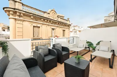 a balcony with chairs and tables on a building at Sitges Group Soul in Sitges