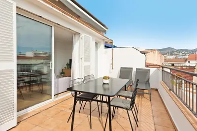 a balcony with a black table and chairs on it at Sitges Group Soul in Sitges