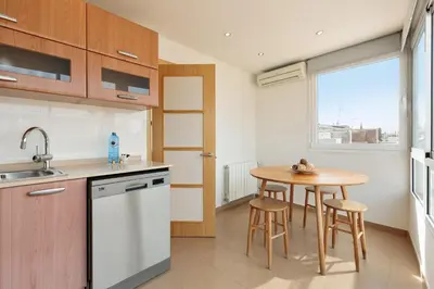 a kitchen with a table and a small table with stools at Sitges Group Soul in Sitges
