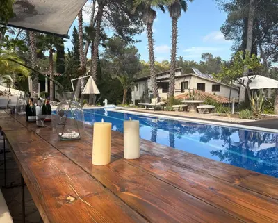 a wooden table with candles on top of a pool at Villa Palmera in Olivella