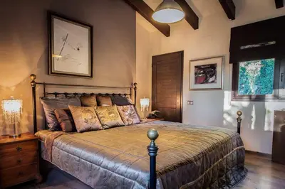 a bedroom with a bed and a clock on the wall at Villa Palmera in Olivella