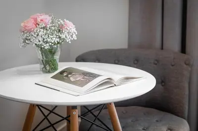 a table with a book and a vase of flowers at Duquesa Suites Landmark Hotel by Grup Duquessa in Barcelona
