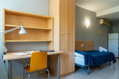 a room with a desk and a bed in a room at Apartaments Turístics Residencia Vila Nova in Vilanova i la Geltrú