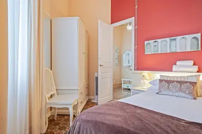 a bedroom with a bed and a red wall at Villa Modernista in Barcelona