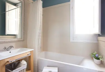 a bathroom with a white tub and a sink at Villa Modernista in Barcelona