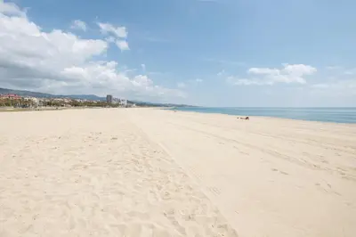 a beach with footprints in the sand and the ocean at Matarolux 5 in Mataró