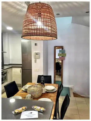 a dining room table with a light fixture above it at Casas Apartamentos Gracia in Barcelona