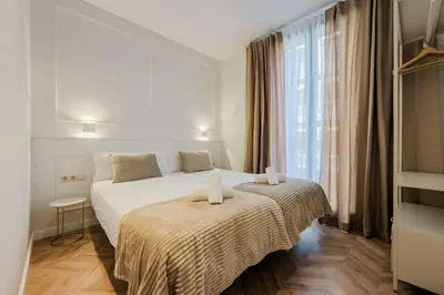 a kitchen with white cabinets and a table and chairs at Four Petals Barcelona Boutique Apartments in Barcelona