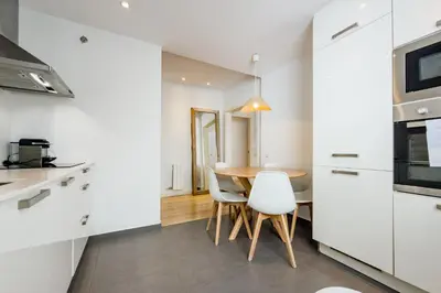 a kitchen with a wooden table with chairs and a dining room at Four Petals Barcelona Boutique Apartments in Barcelona