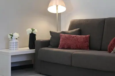 a living room with a couch and a table with flowers at Suite Place Barcelona Còrsega in Barcelona