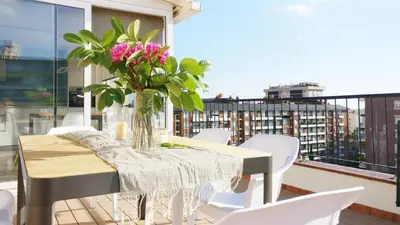 a table with a vase of flowers on a balcony at Ferran Pedralbes Penthouse in Barcelona