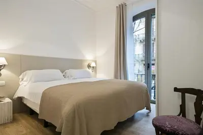 a bedroom with a large white bed and a window at Apartment in downtown Barcelona - Vintage in Barcelona