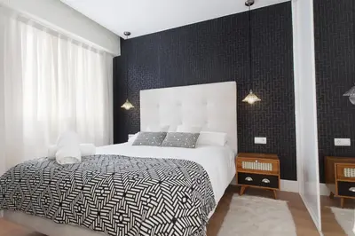 a bedroom with a bed with a black wall at Passeig de Gracia Apartment in Barcelona