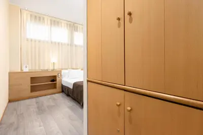 a room with a bedroom with a bed and a cupboard at Apartamentos DV in Barcelona