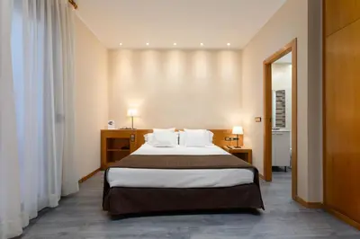 a hotel room with a large bed with white pillows at Apartamentos DV in Barcelona