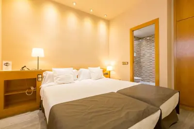 a bedroom with a large white bed in a room at Apartamentos DV in Barcelona