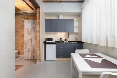 a kitchen with a table and a counter top at Apartamentos DV in Barcelona