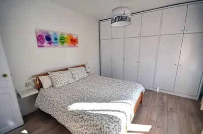 a bedroom with a bed and a painting on the wall at Sunny Apartment Central Sitges in Sitges