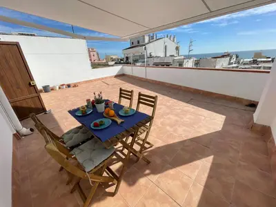a table and chairs on top of a roof at Sunny Apartment Central Sitges in Sitges