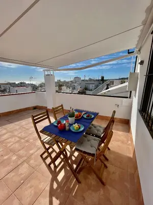 a dining table and chairs on a balcony with a view at Sunny Apartment Central Sitges in Sitges
