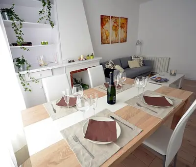 a dining room with a table with wine glasses at Sunny Apartment Central Sitges in Sitges