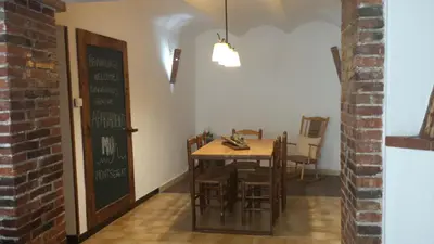 a dining room with a table and chairs and a chalkboard at Apartments Mo in Monistrol
