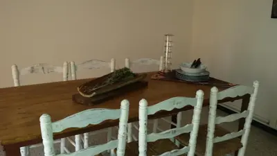 a dining room table with white chairs and a table with plates at Apartments Mo in Monistrol