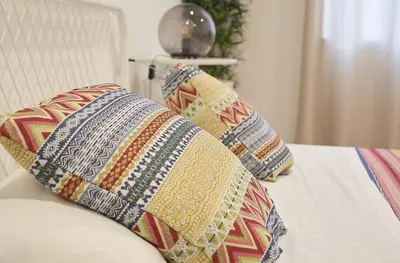 a group of pillows sitting on top of a bed at Central and Basic Universitat for YOUNG HOSTEL in Barcelona