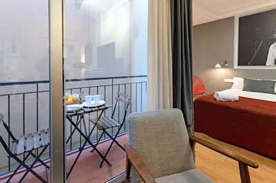 a bedroom with a balcony with a bed and a table at Habitat Apartments Hot Jazz in Barcelona