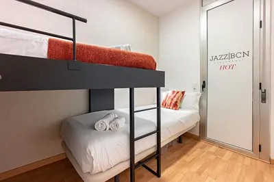 a bedroom with two bunk beds and a mirror at Habitat Apartments Hot Jazz in Barcelona
