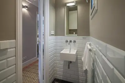 a white bathroom with a sink and a mirror at Habitat Apartments Barcelona Classic in Barcelona