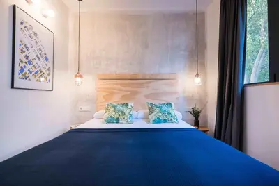 a bedroom with a large blue bed with two pillows at Magatzem 128 in Barcelona