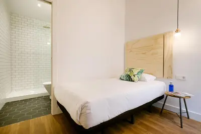 a bedroom with a bed and a bathroom with a tub at Magatzem 128 in Barcelona