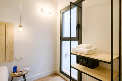 a bathroom with a shelf with towels and a window at Magatzem 128 in Barcelona
