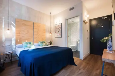a bedroom with a blue bed and a bathroom at Magatzem 128 in Barcelona