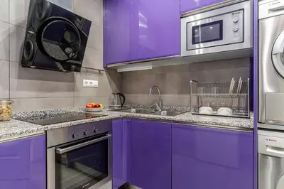 a purple kitchen with a sink and a microwave at Enjoybcn Tapies Apartment in Barcelona