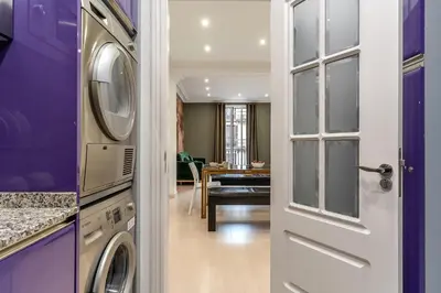 a laundry room with a washer and dryer next to a door at Enjoybcn Tapies Apartment in Barcelona