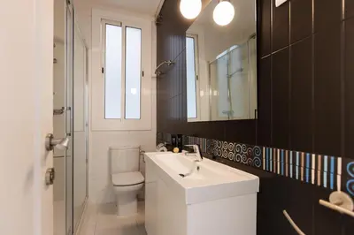a bathroom with a sink and a toilet and a mirror at Enjoybcn Tapies Apartment in Barcelona