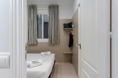 a small room with two beds and a window at Enjoybcn Tapies Apartment in Barcelona