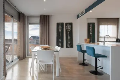 a kitchen and dining room with a table and chairs at Enjoybcn Marina Apartment in Barcelona