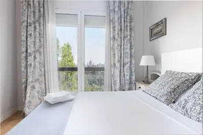 a bedroom with a large white bed and a window at Housalia Guell Gaudi in Barcelona