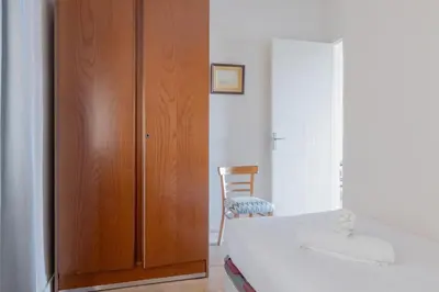 a bedroom with a bed and a wooden closet at Housalia Guell Gaudi in Barcelona