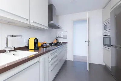 a kitchen with white cabinets and a sink at Housalia Guell Gaudi in Barcelona