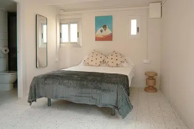 a white bedroom with a bed and a bathroom at Smartr Barcelona Ramblas in Barcelona