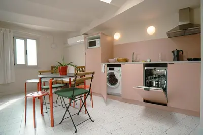 a kitchen with a table and chairs and a washing machine at Smartr Barcelona Ramblas in Barcelona