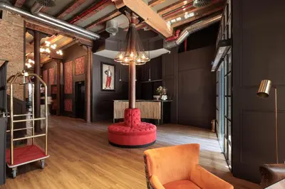 a living room with a red chair and a table at Hotel La Pau in Barcelona