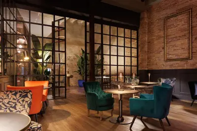 a restaurant with colorful chairs and tables and windows at Hotel La Pau in Barcelona