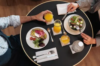 two people sitting at a table with plates of food at Hotel La Pau in Barcelona