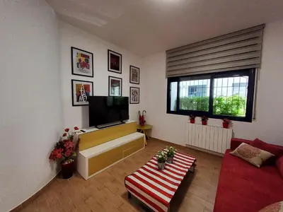 a living room with a television and a red couch at Apartment Sant Sebastià in Sitges