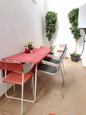 a red table and chairs in a room with plants at Apartment Sant Sebastià in Sitges